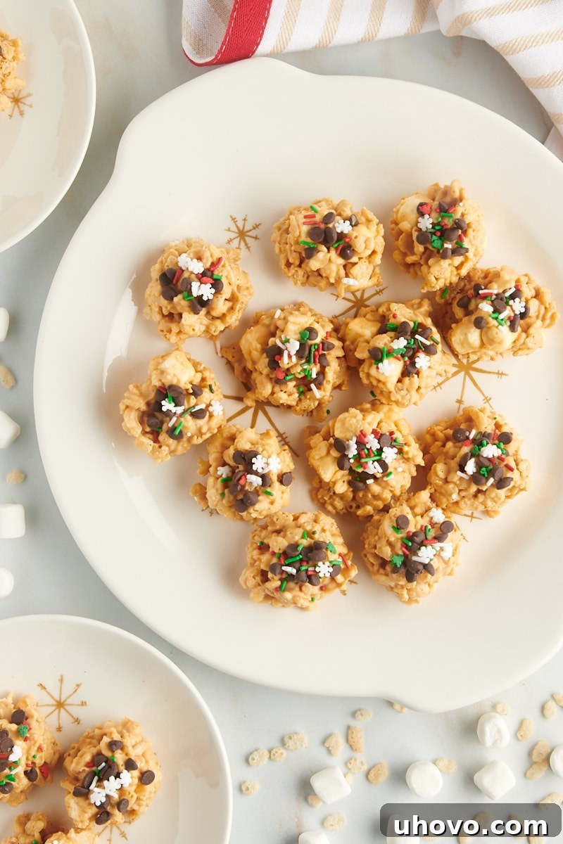 overhead view of avalanche cookies on a large white plate with rice cereal and mini marshmallows scattered around the plate