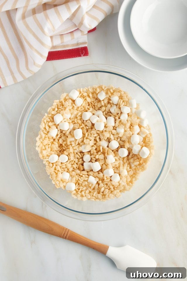 overhead view of rice cereal and mini marshmallows mixed in a glass bowl