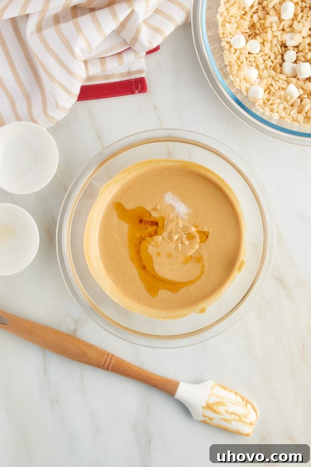 overhead view of vanilla extract and salt added to melted white chocolate and peanut butter