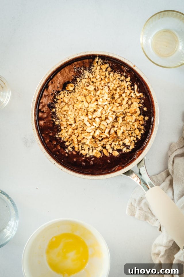 Overhead view of chopped pecans in saucepan of pie filling