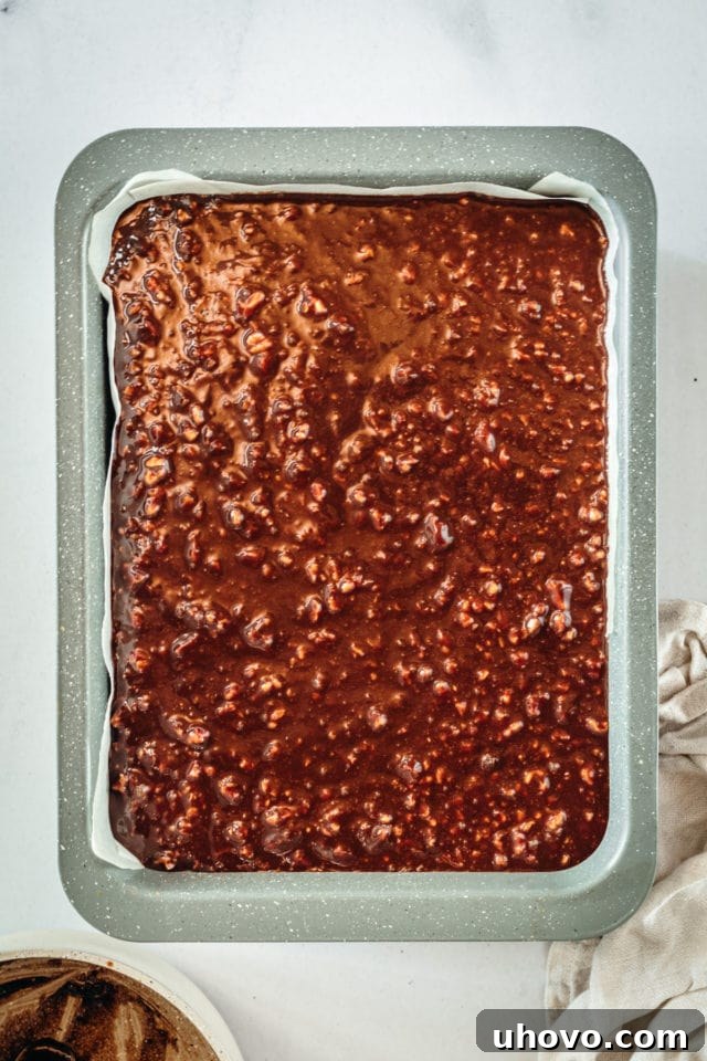 Overhead view of pecan pie bars in baking dish before baking