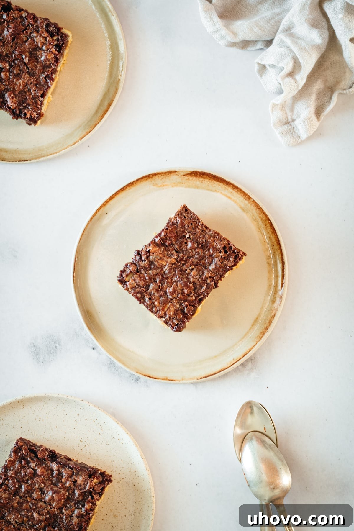 Overhead view of three plates, each with several chocolate pecan pie bars