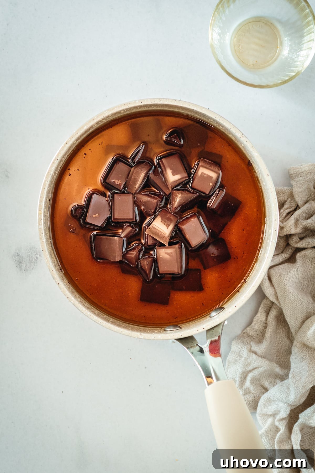 Overhead view of chocolate being melted into corn syrup in a bowl