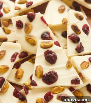 a big pile of cranberry pistachio bark on a cutting board, perfect for sharing