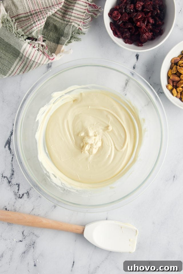 overhead view of perfectly melted, smooth white chocolate in a clear glass bowl, ready to be poured