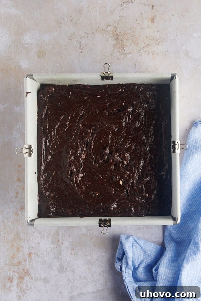 Overhead view of smooth brownie batter evenly spread in the prepared baking pan.