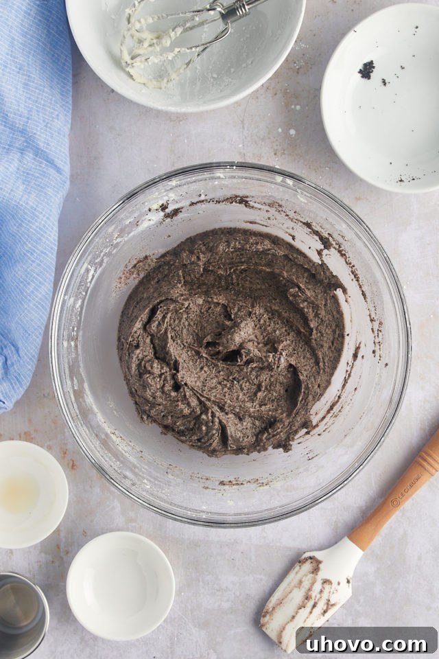 Overhead view of the finished Oreo frosting, light and fluffy, in a glass mixing bowl.
