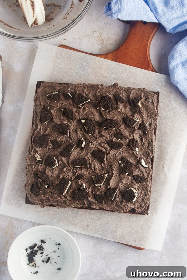 Overhead view of a tray of frosted Oreo brownies, prepared for slicing and serving.