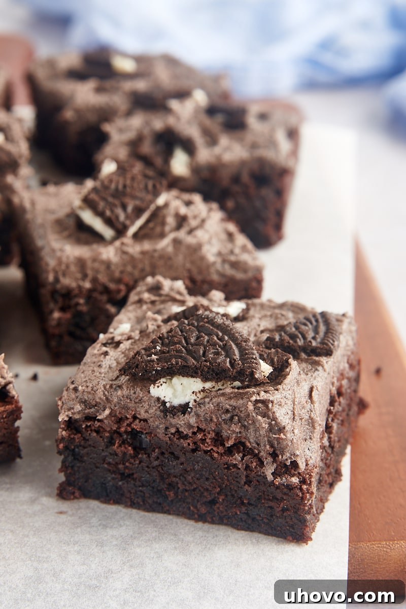 Oreo brownies arranged neatly on a parchment-lined board, showcasing their perfect squares and delicious frosting.