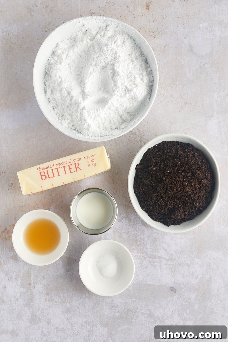 Overhead view of ingredients for the creamy Oreo frosting, including butter, powdered sugar, milk, and crushed Oreos.