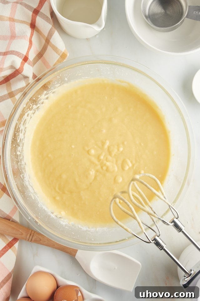 A perfectly smooth and creamy cake batter in a large mixing bowl, showcasing its readiness for layering in the baking pan.