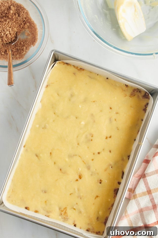 The second layer of golden cake batter gently spread over the cinnamon-sugar filling, creating a harmonious and layered structure for the honey bun cake.