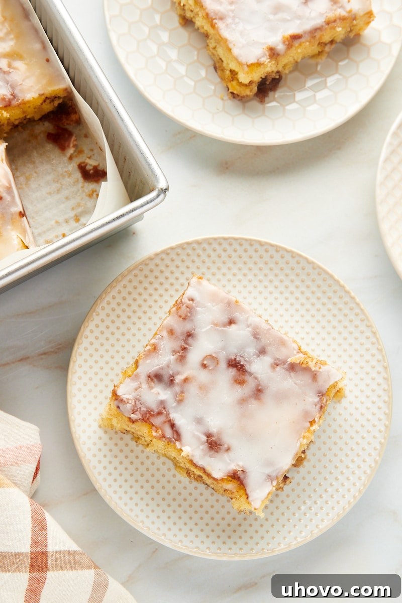 Two individual plates showcasing slices of the delicious honey bun cake, each perfectly glazed and ready to be enjoyed as a delightful dessert.