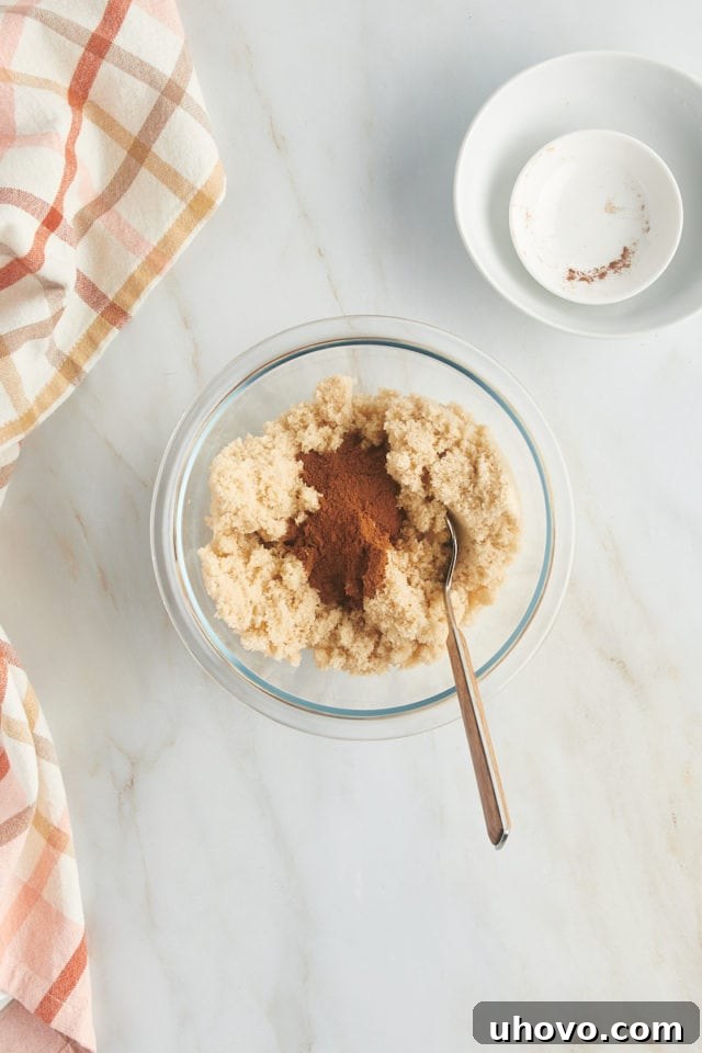 An overhead view of a bowl containing light brown sugar and ground cinnamon, ready to be mixed for the cake's delicious swirl filling.