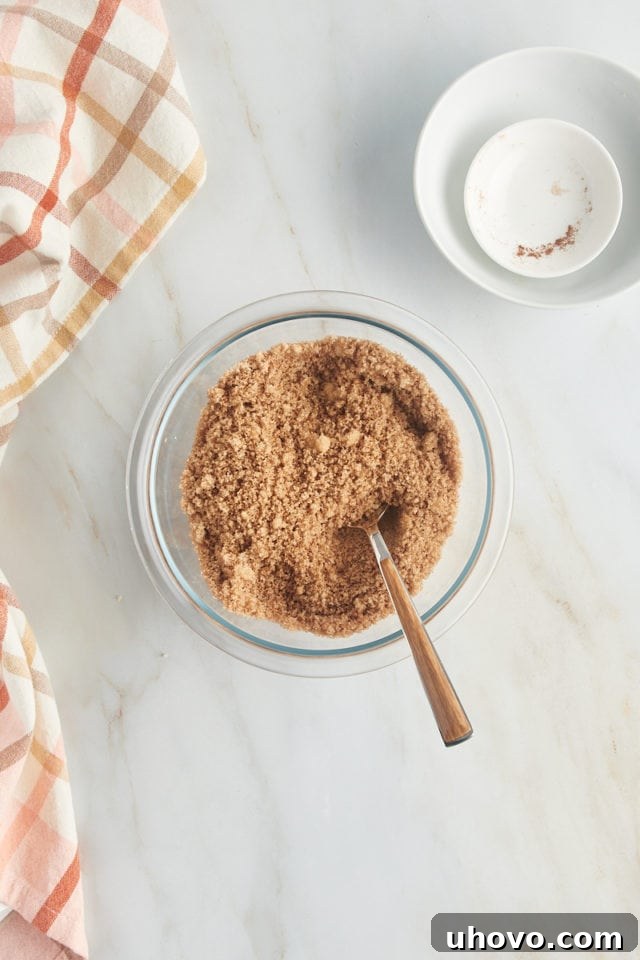 Close-up shot of the perfectly blended brown sugar and cinnamon mixture in a bowl, showing the rich color and texture of the cake's filling.