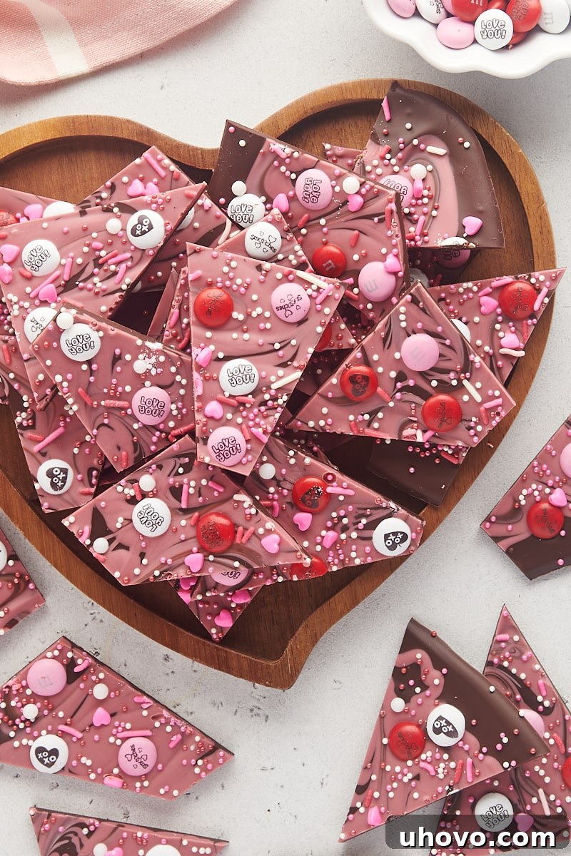 Overhead view of marbled Valentine's bark arranged on a heart-shaped wooden tray, surrounded by more bark pieces.