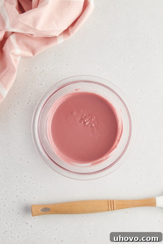Overhead view of melted ruby chocolate in a glass bowl, showcasing its beautiful pink hue.