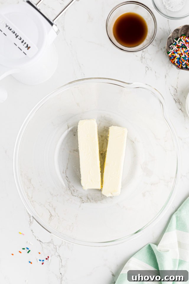 Overhead view of softened unsalted butter in a clear glass mixing bowl, ready to be beaten for vanilla buttercream.