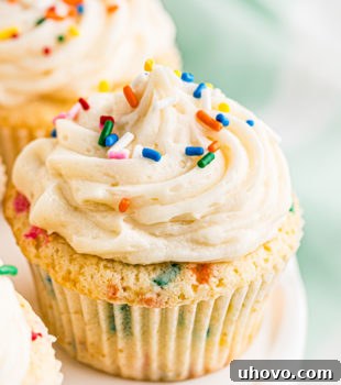 a confetti cupcake on a white cake stand