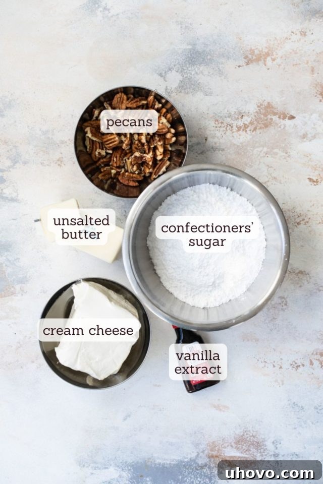 Overhead view of various ingredients laid out for making butter pecan cake frosting, including cream cheese, butter, and pecans.