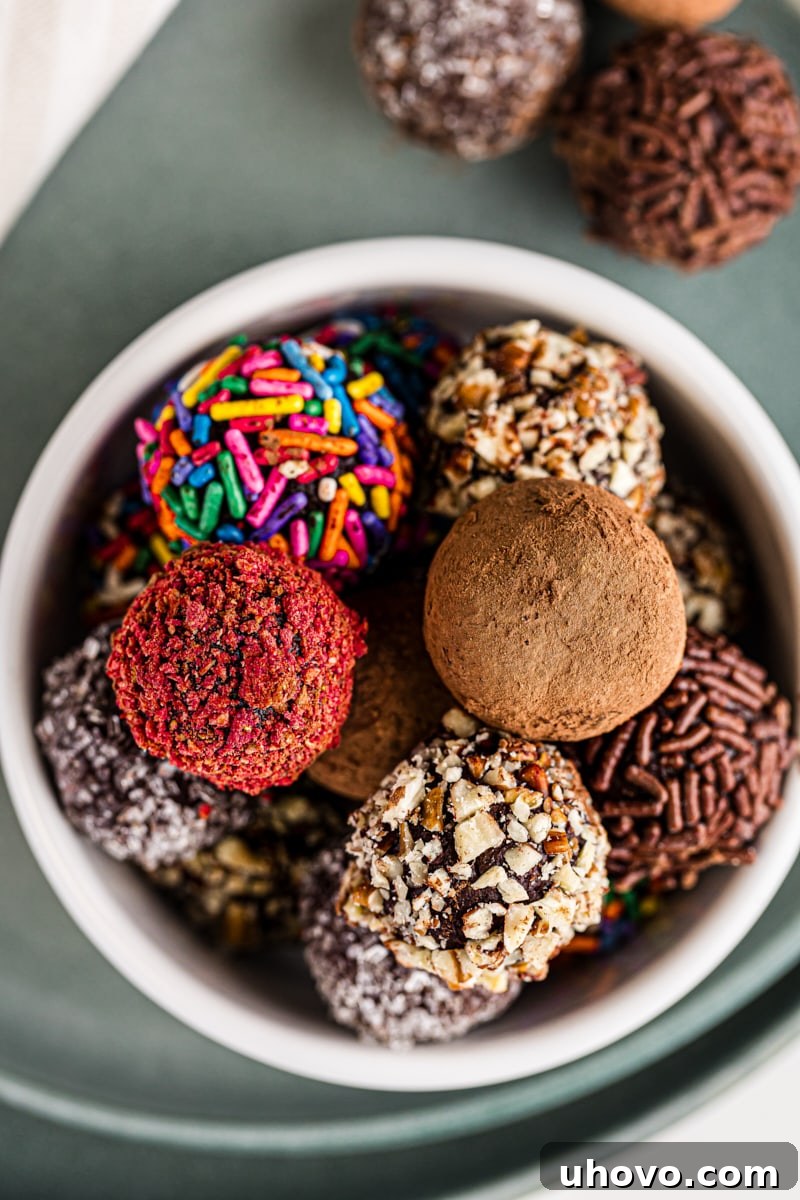 A white ceramic bowl brimming with an assortment of dark chocolate truffles, neatly arranged and ready to be savored, placed on a vibrant green plate.