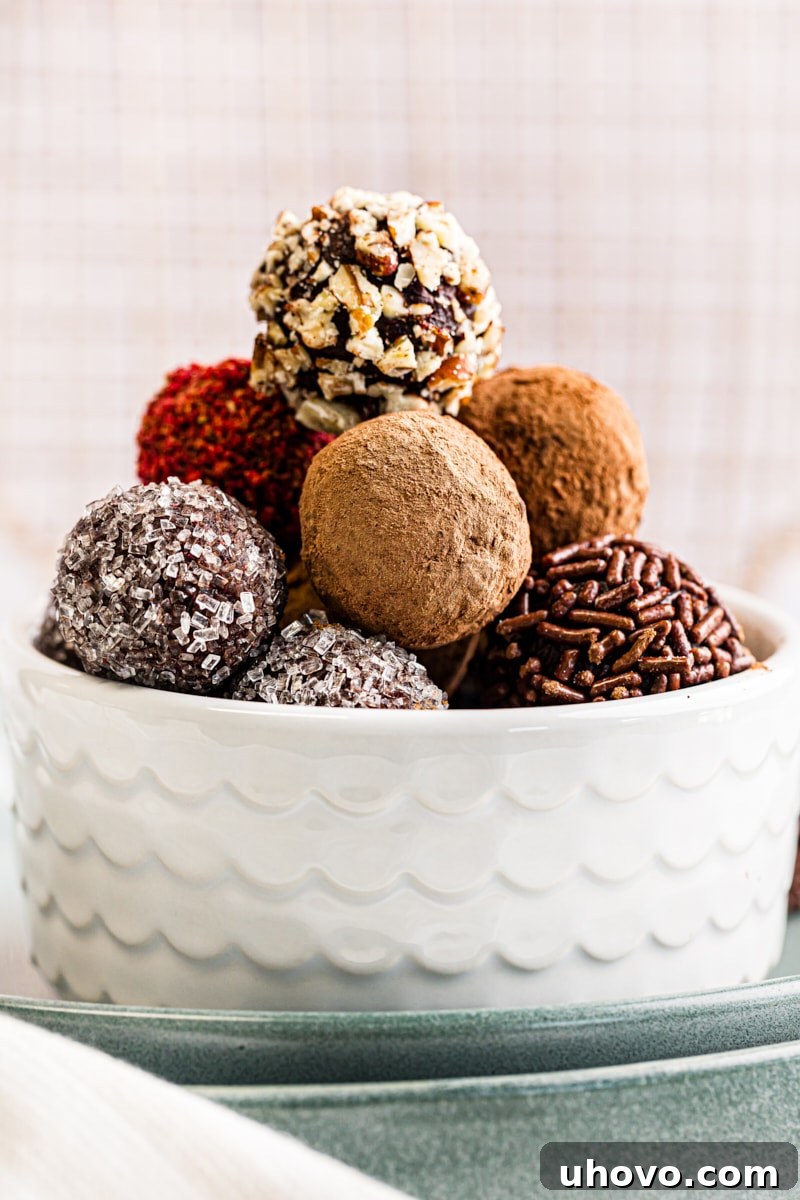 A perfectly composed shot of a pristine white bowl generously filled with a vibrant assortment of homemade chocolate truffles, ready for enjoyment.