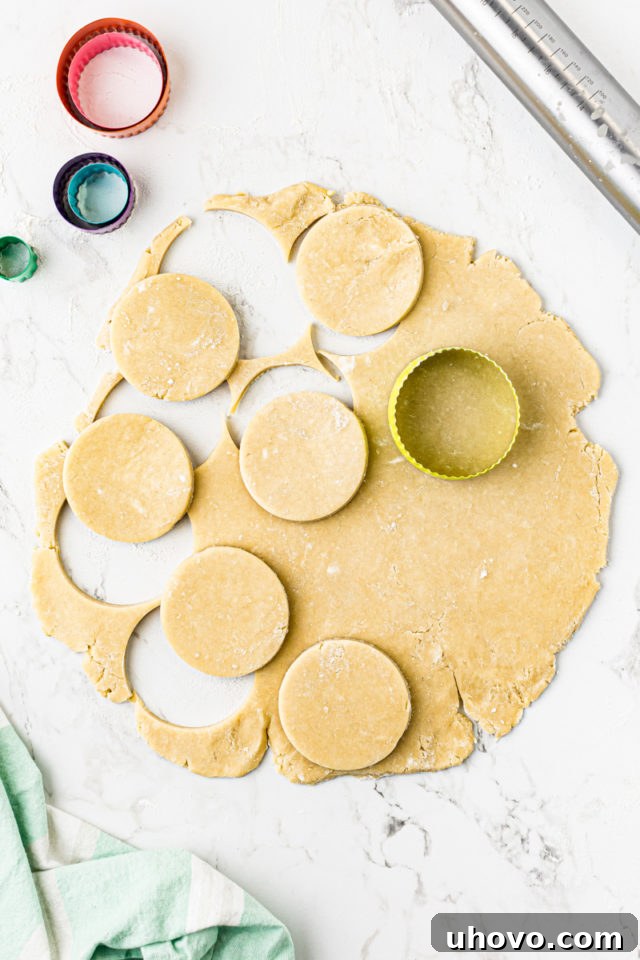 Overhead view of chilled Lofthouse cookie dough rolled to 1/4-inch thickness, with several 3-inch rounds already cut out.
