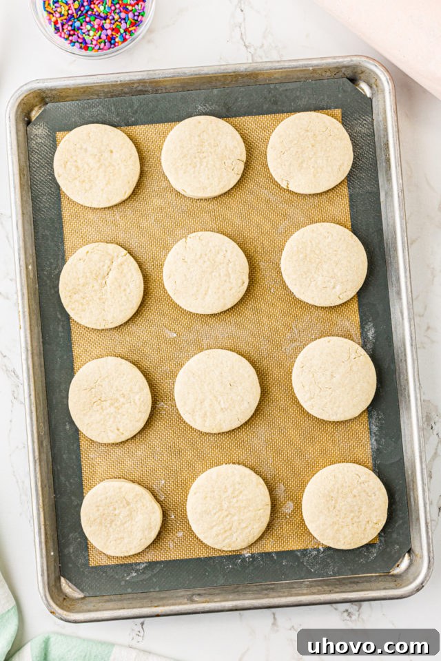 Overhead view of a baking sheet filled with freshly baked Lofthouse cookies, perfectly puffed and still light in color.