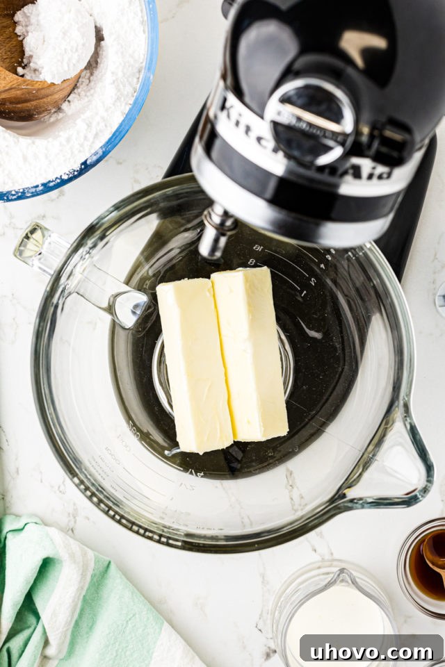 Overhead view of softened unsalted butter in the bowl of a stand mixer, ready to be beaten.