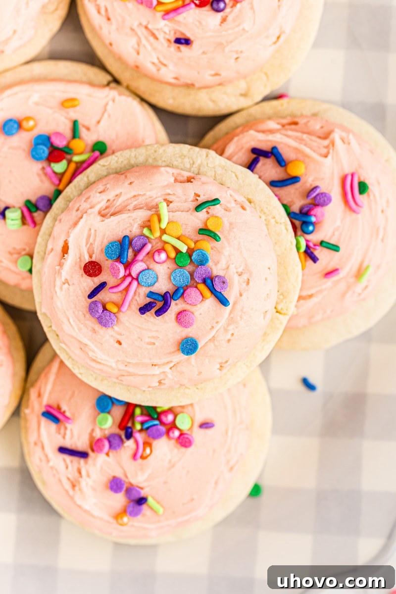 Overhead view of a stack of Lofthouse cookies on a grey and white checked plate, showcasing their soft texture and vibrant frosting.
