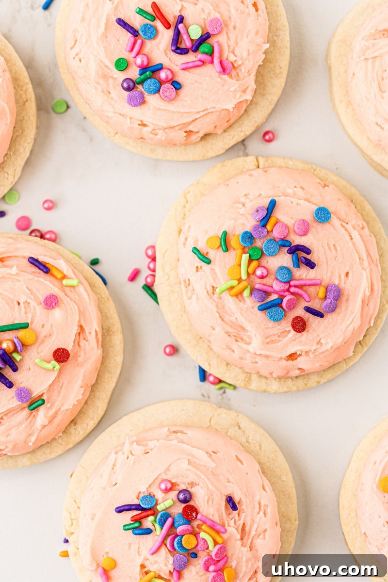 An overhead view of freshly baked, unfrosted Lofthouse cookies cooling on a wire rack against a marble countertop.
