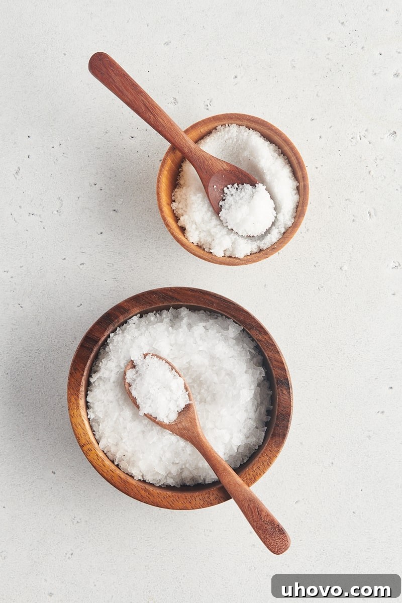 overhead view of fine sea salt and large flake sea salt in wooden bowls