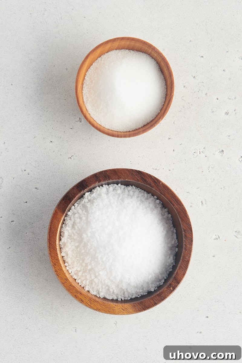 overhead view of table salt and kosher salt in wooden bowls