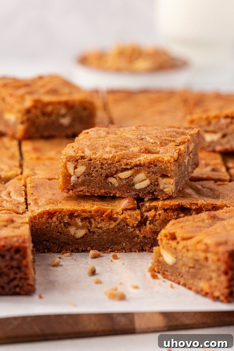 Brown butter blondies cooling on a parchment-lined cutting board, freshly baked and ready for slicing.