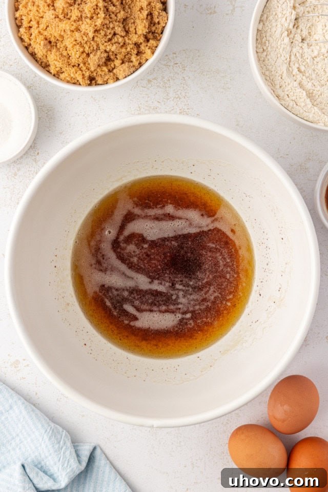 Butter being browned in a saucepan, showing golden specks forming at the bottom and a light foam on top.