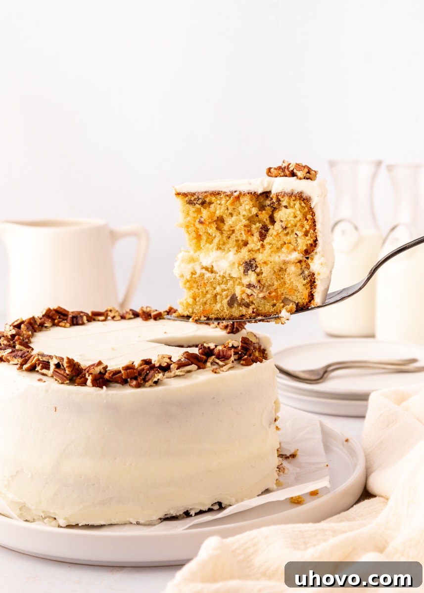 a slice of carrot cake on a cake server being lifted from the remaining cake