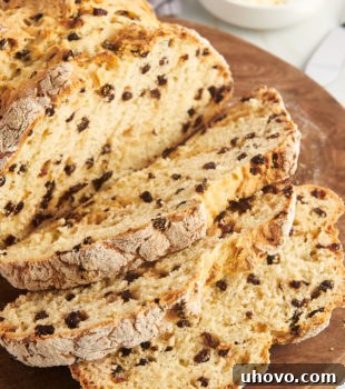 partially sliced Irish soda bread on a round wooden board