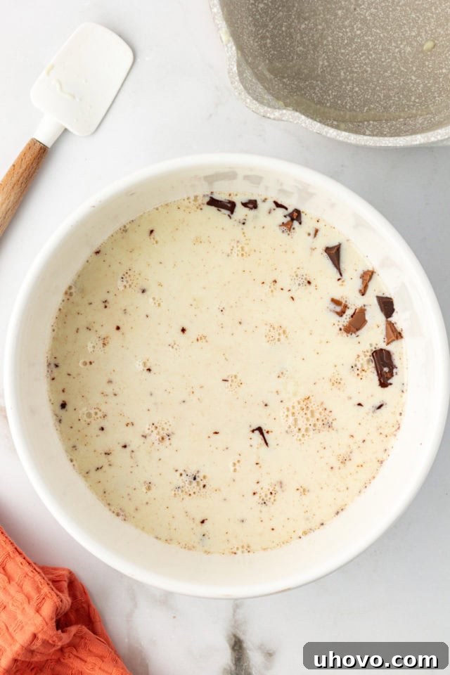 Warm cream poured over chopped chocolate for hot fudge sauce