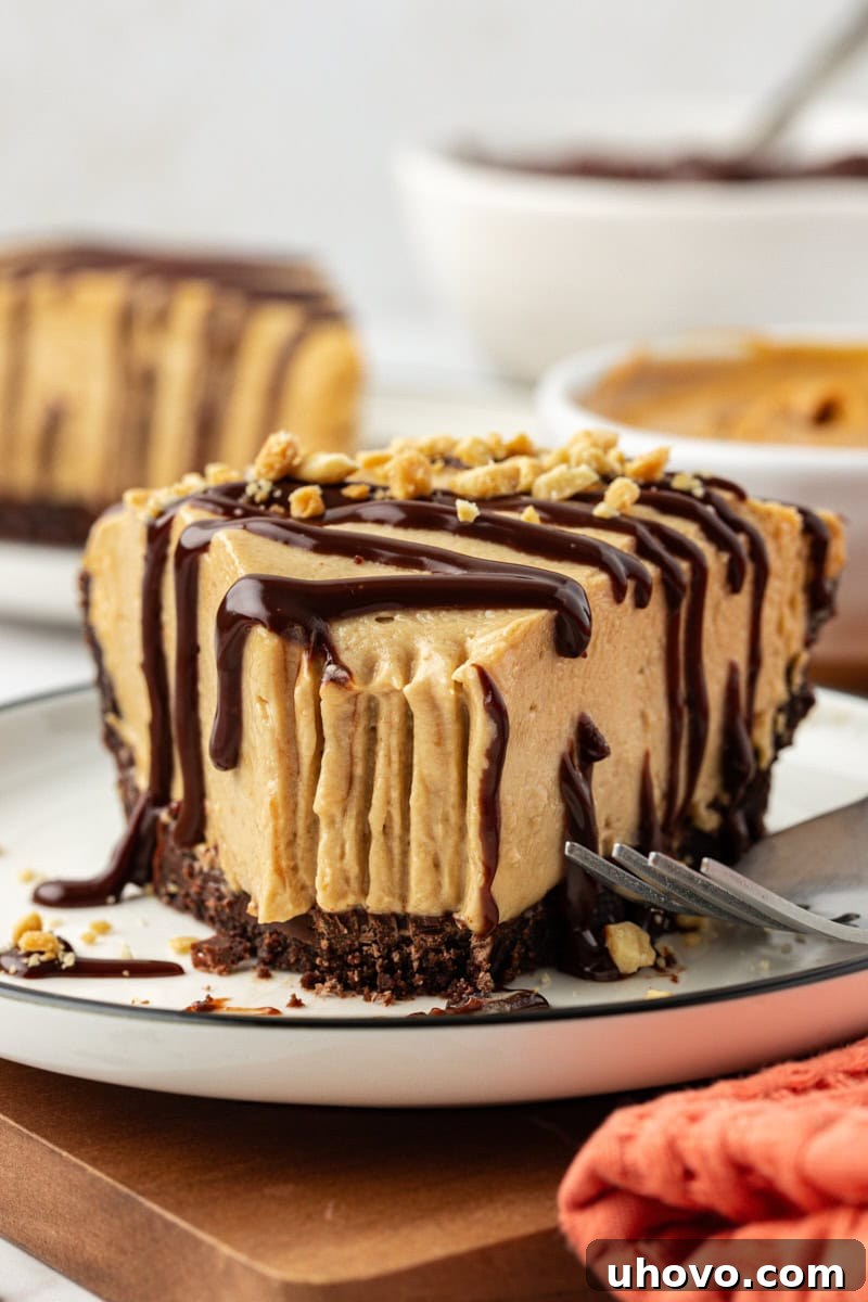 A slice of peanut butter pie on a plate with a bite taken out, showing the creamy texture.