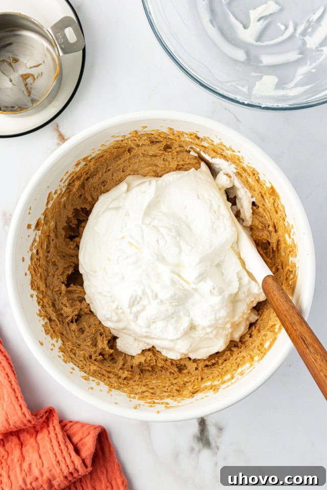 Whipped cream being folded into peanut butter filling ingredients