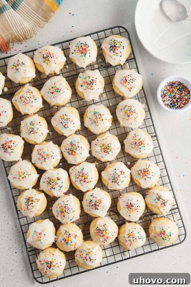 overhead view of sour cream cookies topped with glaze and sprinkles on a wire rack