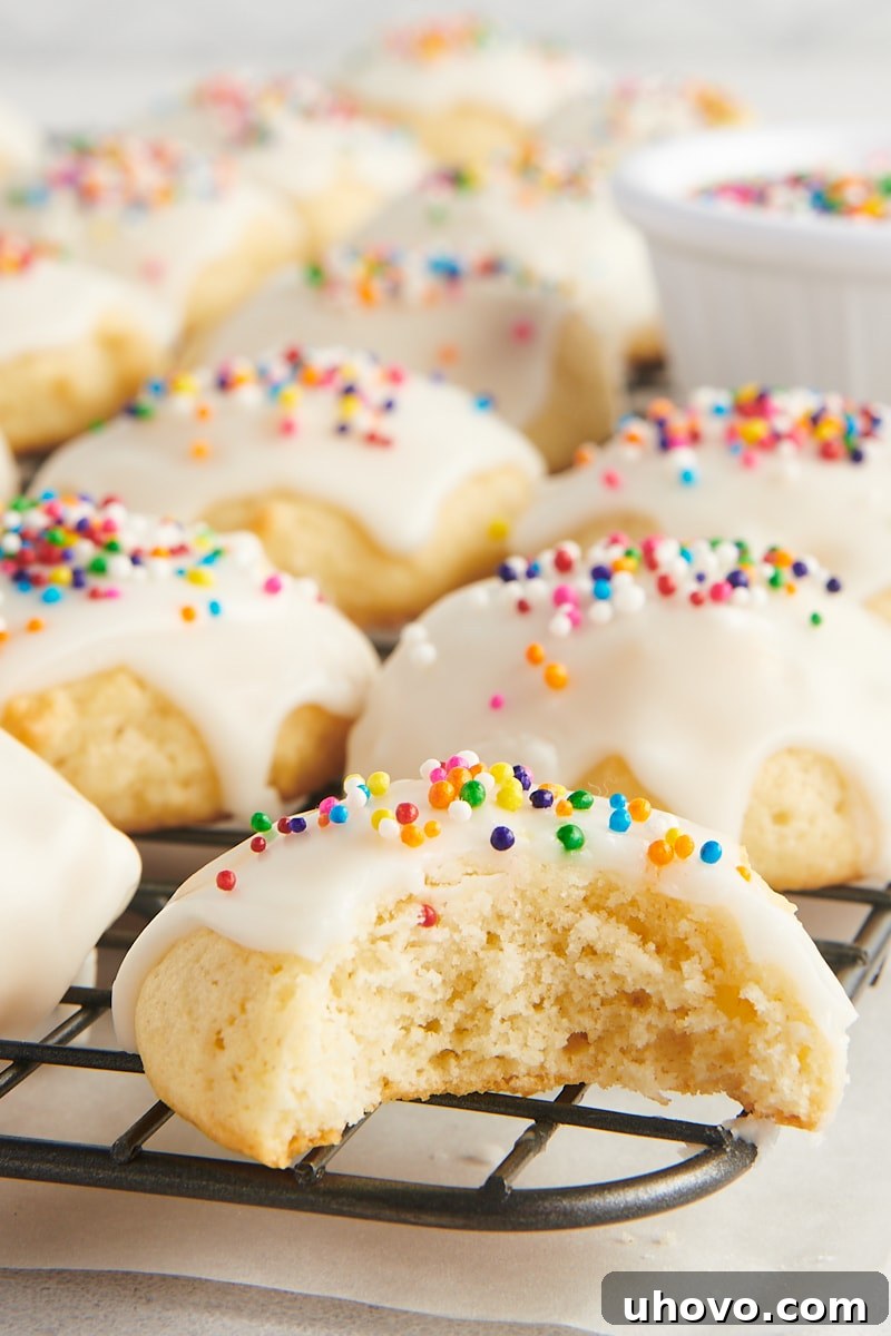 a sour cream cookie with a bite missing, surrounded by more cookies on a wire rack
