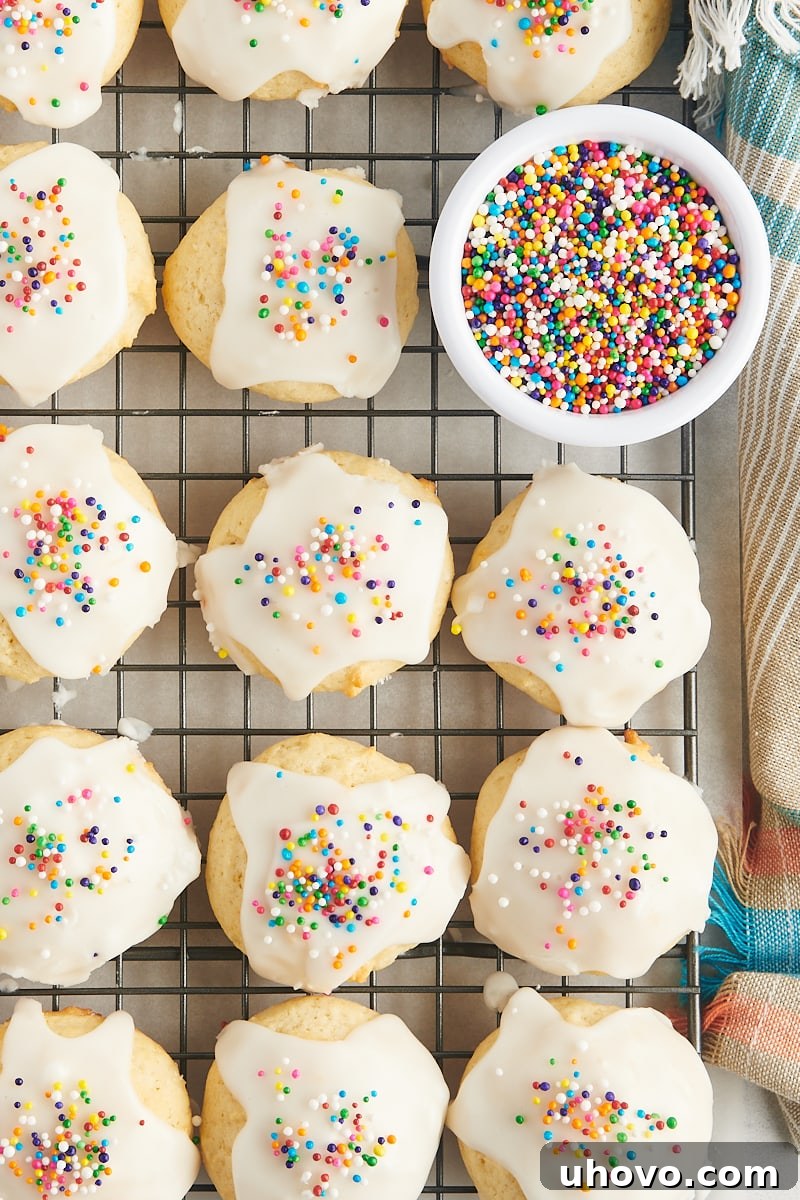 overhead view of sour cream cookies and a small bowl of sprinkles on a wire rack