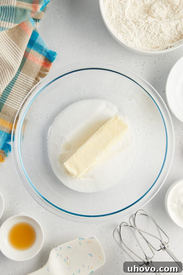 overhead view of butter and sugar in a glass mixing bowl