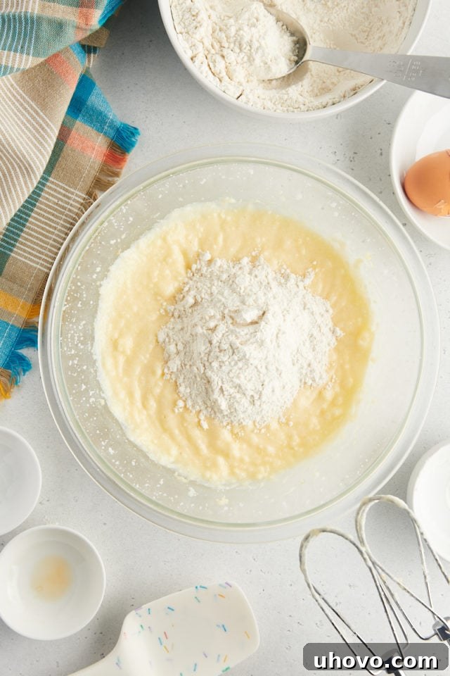 overhead view of dry ingredients added to wet ingredients for sour cream cookies