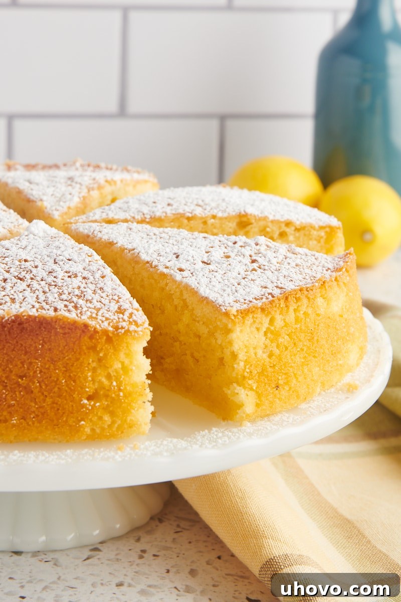 partially sliced olive oil cake on a white cake stand