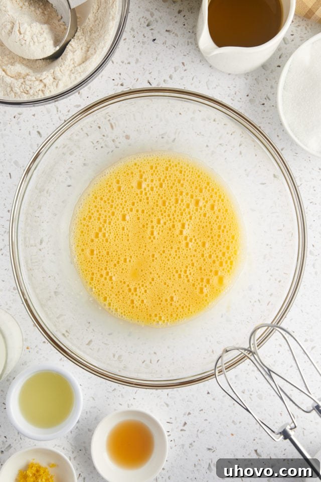 overhead view of beaten eggs in a glass mixing bowl