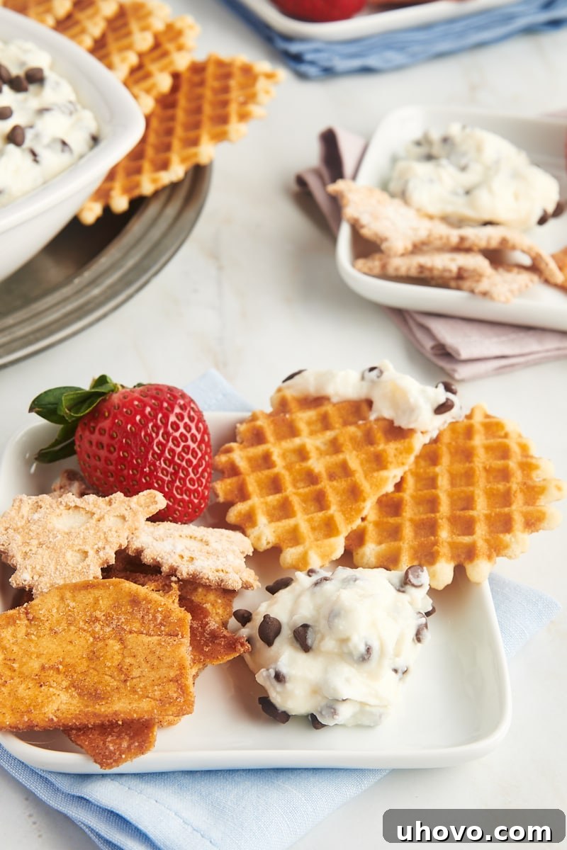 cannoli dip and various dippers served on a white plate with more of both in the background
