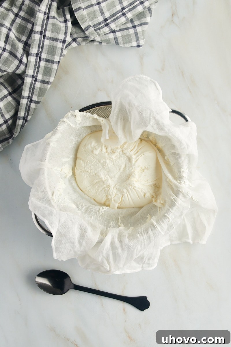 overhead view of ricotta cheese being strained through a cheesecloth