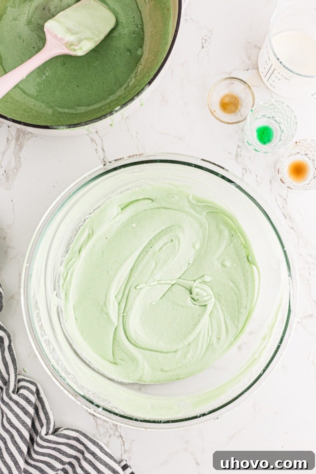 The fully mixed, fluffy, and evenly green filling for Grasshopper Pie in a glass mixing bowl, showcasing its smooth texture.